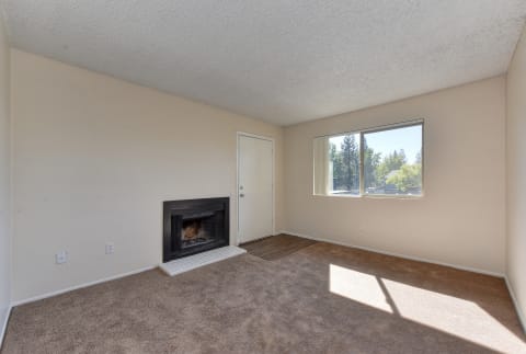 Upstairs vacant home with plush carpeting, and fireplace located in the living room.